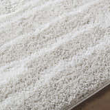 Close-up of the ivory Carlen Area Rug, a soft shag rug with subtle peach tones and a machine-woven construction. Texture
