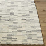 Close-up of the Max Handmade Becki Owens x LIVABLISS Area Rug. Ivory wool rug with a contemporary blue and gray geometric pattern. Front