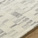 Close-up of the Max Handmade Becki Owens x LIVABLISS BOMX-2303 Area Rug. Ivory wool with charcoal and gray geometric pattern. Texture