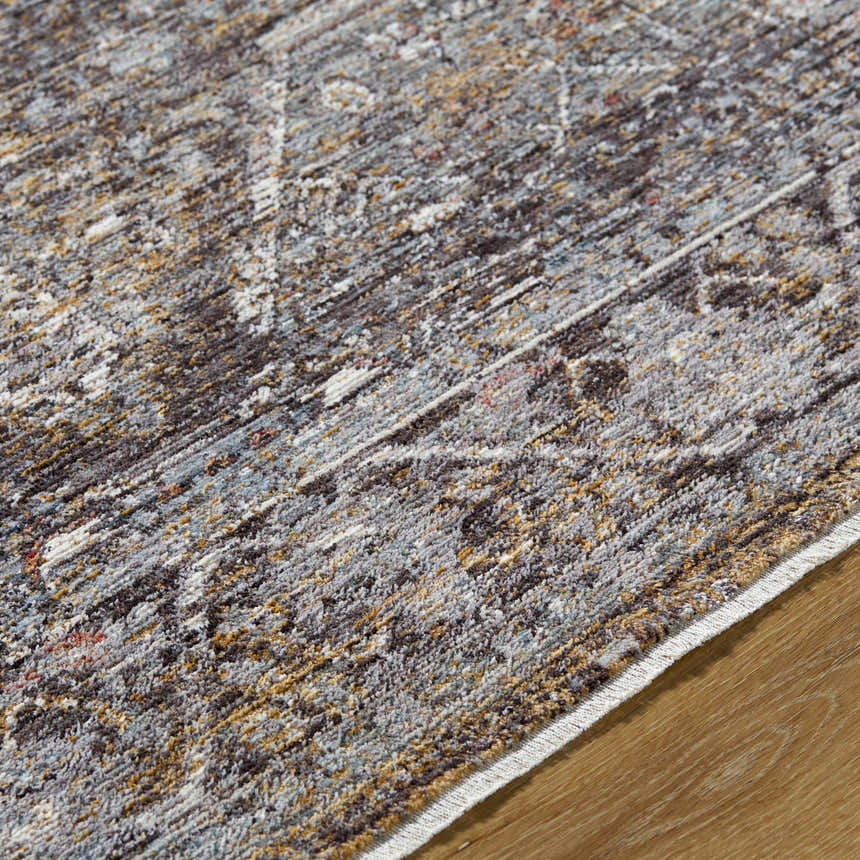 Close-up of the Clovia Area Rug showing its black, gray, ivory, and brown traditional pattern and soft texture. Texture