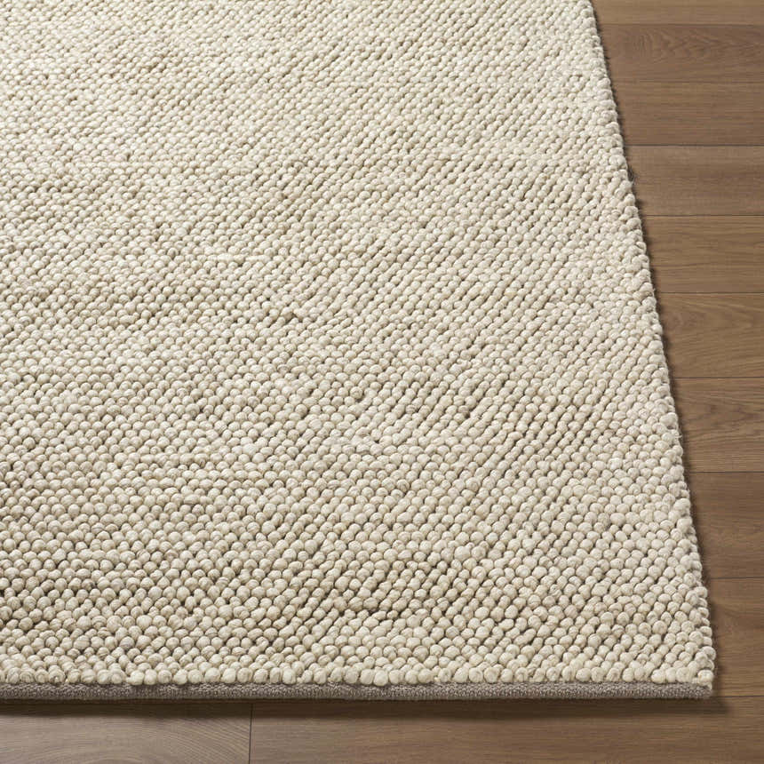 Close-up of the hand-woven Clayne Dark Beige wool area rug, showing its looped texture and medium brown color on wood floor. Front