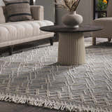 Living room scene with a Ramsbury Denim Blue Wool Rug, beige sofa, and round coffee table with a vase. Roomscene-Rectangle