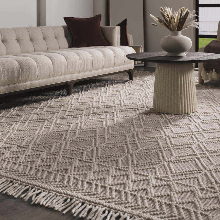 Living room scene with a Ramsbury Soft Pink Wool Rug, beige sofa, and round coffee table. Roomscene-Rectangle