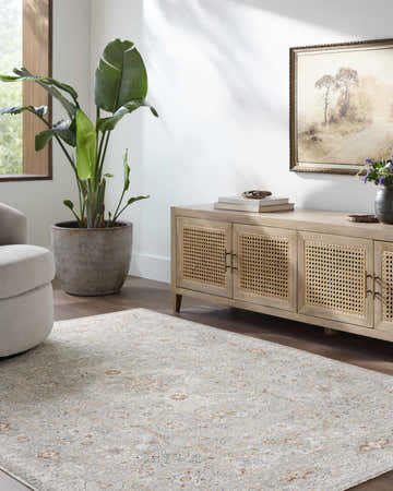 Living room scene with a Chione Cream Area Rug, beige cabinet, potted plant, and neutral decor. Roomscene-Rectangle