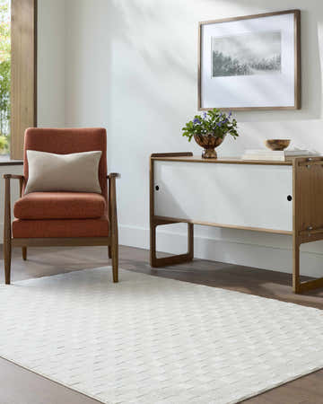 Living room scene with ivory Carina Light 3D Checkered Washable Area Rug, orange chair, and white cabinet. Roomscene-Rectangle