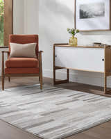 Living room scene with a gray and ivory Ananya Area Rug, orange chair, and white cabinet. Roomscene-Rectangle