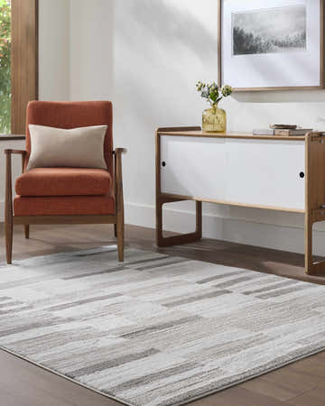 Living room scene with a gray and ivory Ananya Area Rug, orange chair, and white cabinet. Roomscene-Rectangle