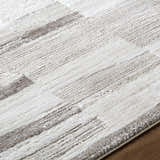 Close-up of the Ananya Area Rug. Ivory, light brown, and gray stripes create a contemporary pattern. Soft polyester texture. Texture