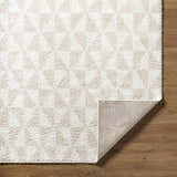 Close-up of the Ceylan Area Rug. Medium gray and white shag rug with geometric pattern. Machine woven polyester rug. Fold