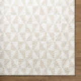 Close up of the Ceylan Area Rug, a shag rug with a geometric triangle pattern in medium gray and white. Corner