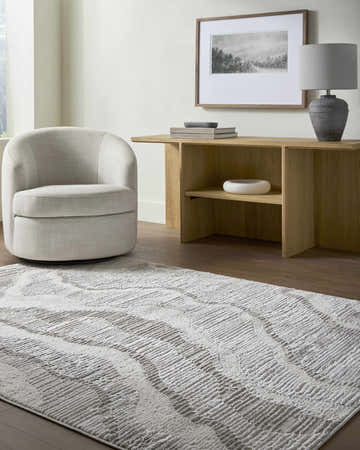 Contemporary living room with a cream chair and the gray and ivory Aniela Area Rug. Roomscene-Rectangle