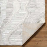 Close-up of the Aniela Area Rug showing its cream, ivory, and gray geometric pattern and textured weave. Fold
