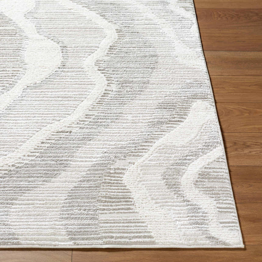 Close up of the Aniela Area Rug, showing its cream, ivory, and gray contemporary pattern and machine woven texture. Front