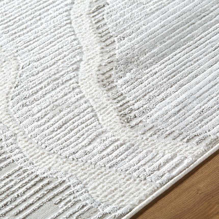 Close up of the Aniela Area Rug, showing cream, ivory, and gray textured geometric pattern. Texture
