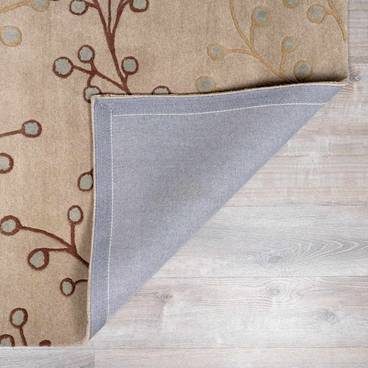 Close-up of the Elsu Beige&Gray Wool Rug, showing floral design, wool texture, and rug backing. Fold