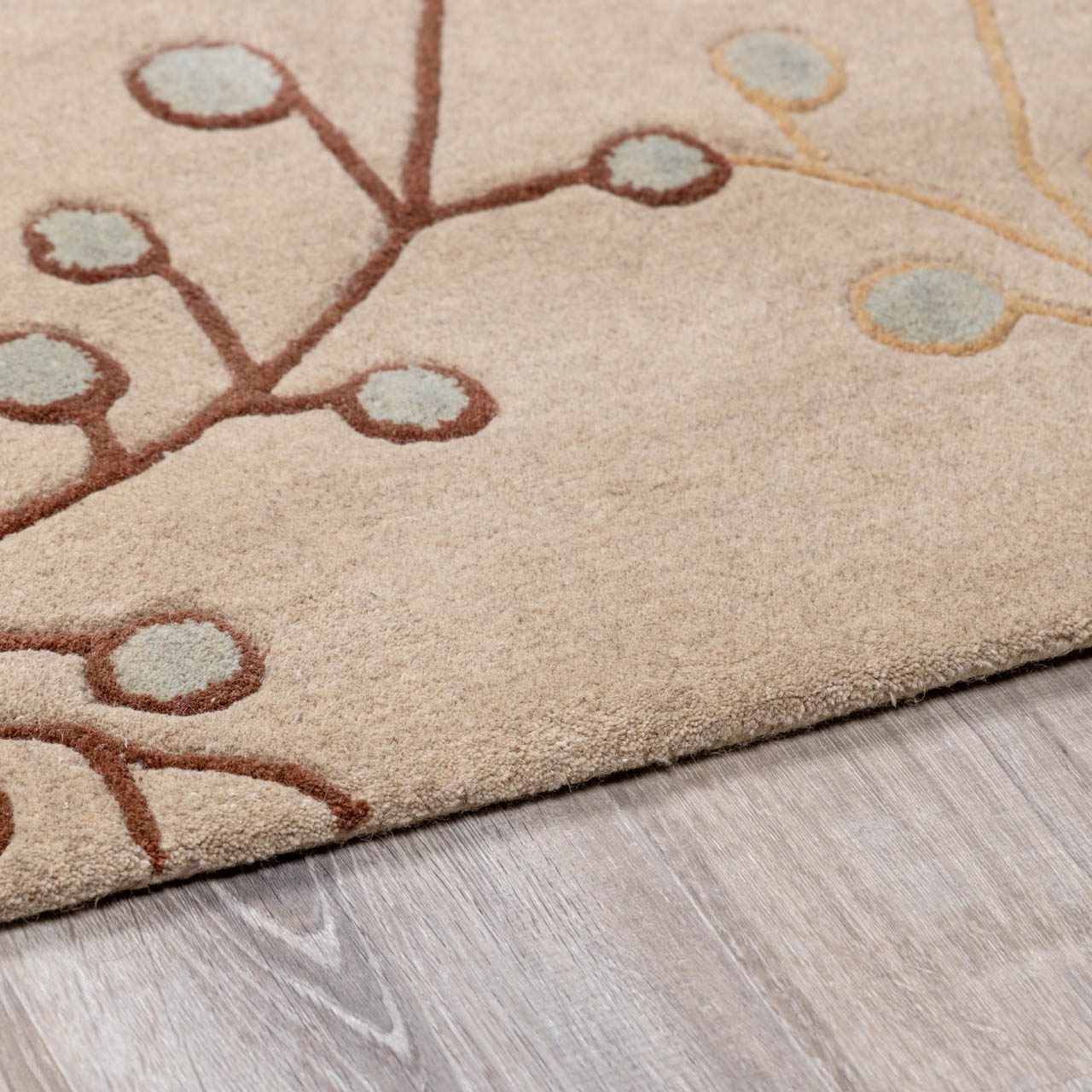 Close-up of the Elsu Beige&Gray Wool Rug showing the floral design, brown stems, and beige wool texture. Pile