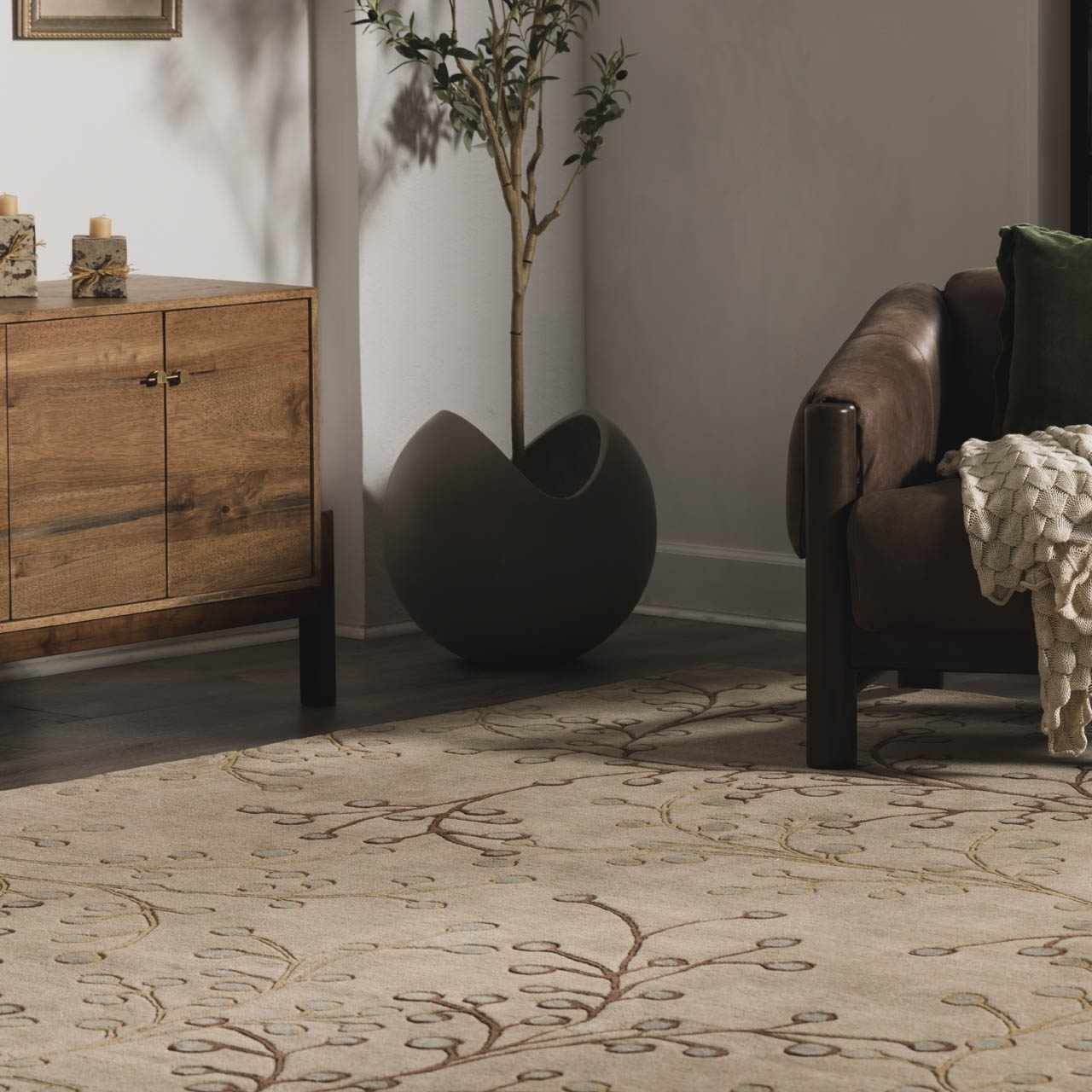 Living room scene with a brown leather armchair on the Elsu Beige&Gray Wool Rug with a floral pattern. Roomscene-Rectangle