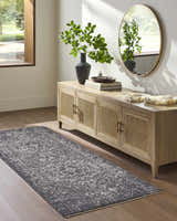 Entryway with a Corina Black runner rug, wood floors, and a console table with a round mirror. Roomscene-Runner