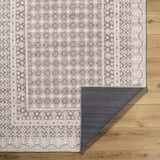 Rainier Light Brown Washable Rug close-up. Cream and light brown farmhouse style rug with traditional geometric pattern. Fold
