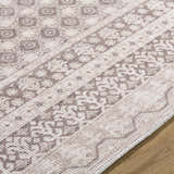 Close-up of the Rainier Light Brown Washable Rug showing its traditional, light brown and cream pattern and machine woven texture. Texture