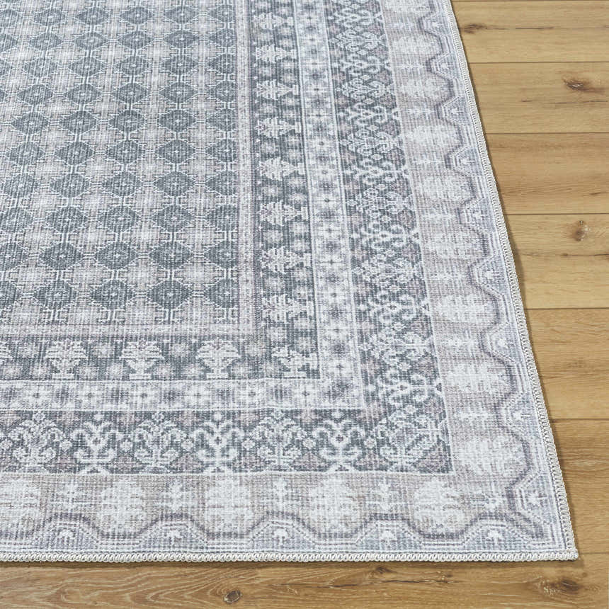 Close-up of the Rainier Gray Washable Rug showing its farmhouse style, traditional pattern, and soft off-white, pale blue, and sage colors. Front