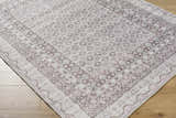 Close-up of the Rainier Brown Washable Rug, a traditional rug with dark brown, light gray, and sage floral patterns. Corner
