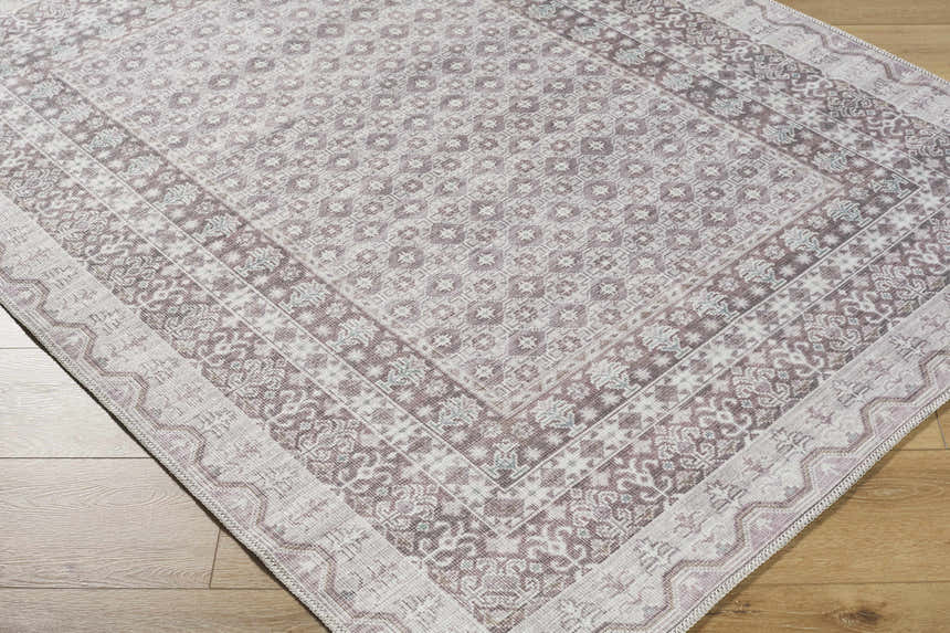 Close-up of the Rainier Brown Washable Rug, a traditional rug with dark brown, light gray, and sage floral patterns. Corner