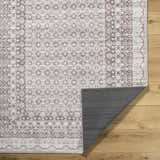 Close-up of Rainier Brown Washable Rug with traditional brown and gray pattern, showing the rug's backing. Fold
