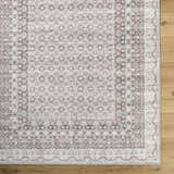 Close-up of Rainier Brown Washable Rug. Traditional farmhouse style with dark brown, light gray, and sage patterns. Corner