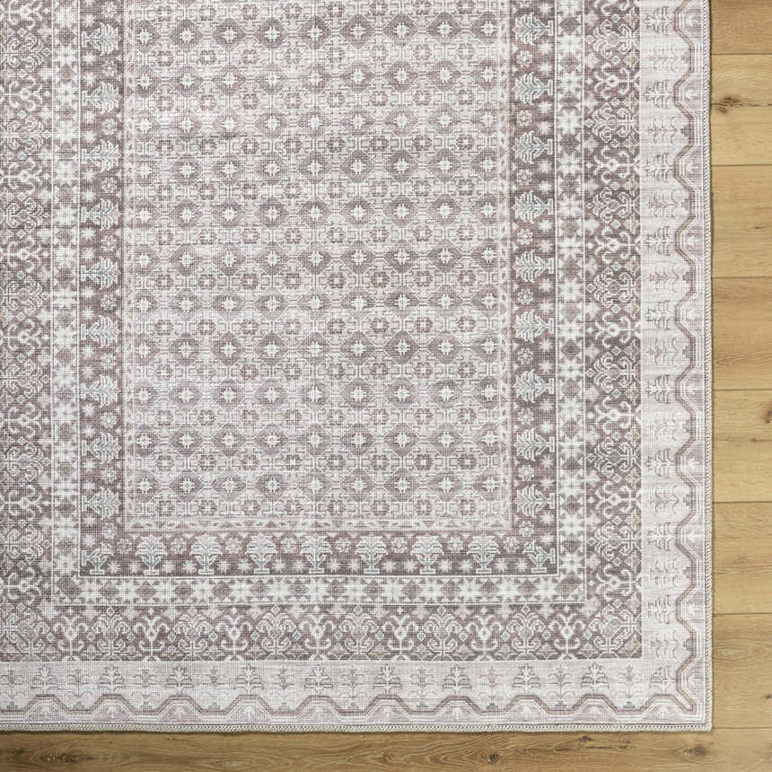 Close-up of Rainier Brown Washable Rug. Traditional farmhouse style with dark brown, light gray, and sage patterns. Corner
