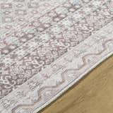 Close-up of the Rainier Brown Washable Rug showing its traditional, farmhouse pattern and brown, gray, and sage colors. Texture