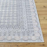 Close-up of Rainier Blue Washable Rug showing its traditional pale blue, white, and green pattern and machine woven texture. Front