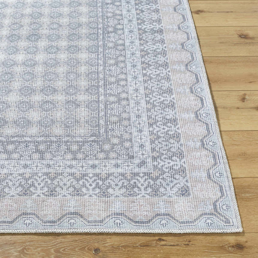 Close-up of Rainier Blue Washable Rug showing its traditional pale blue, white, and green pattern and machine woven texture. Front