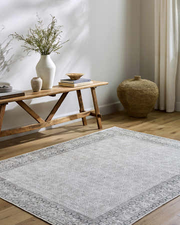 Entryway with Rainier Cottage Border Gray Washable Rug, wood bench, vases, books, and woven basket. Farmhouse style. Roomscene-Rectangle
