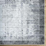 Close-up of the Colson Gray Area Rug, featuring a contemporary light silver, onyx, and silver gray pattern. Corner