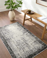 Minimalist entryway with a Colson Gray Area Rug, wooden bench, vase, and wood floors. Roomscene-Runner