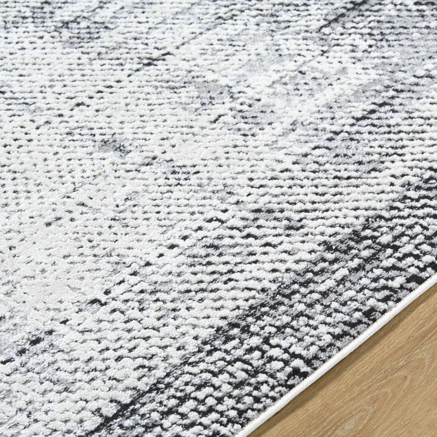 Close-up of the Colson Gray Area Rug showing its light silver, onyx, and silver gray contemporary pattern. Texture
