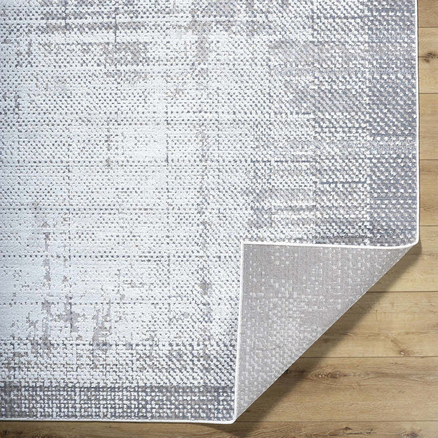 Close-up of Colson Sage area rug showing ash, silver gray, and slate blue contemporary pattern and machine woven texture. Fold