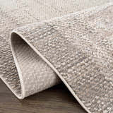 Close-up of the Colson Sage Area Rug showing its textured weave, ash, and silver gray tones with a neutral trim. Fold