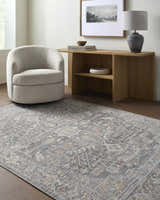 Living room scene with a Xiye Silver Medallion rug, light gray chair, and wooden console table with lamp and artwork. Roomscene-Rectangle