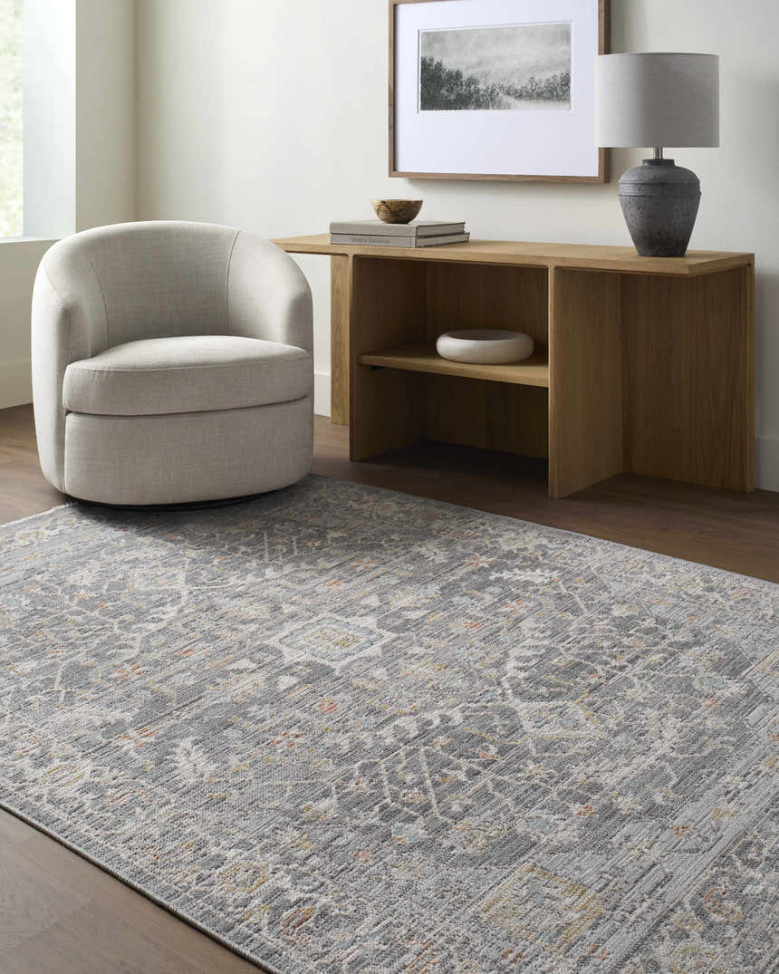 Living room scene with a Xiye Silver Medallion rug, light gray chair, and wooden console table with lamp and artwork. Roomscene-Rectangle
