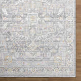 Close-up of the Xiye Silver Medallion Rug. Machine-woven polypropylene with a traditional medallion pattern in silver, gold, and blue. Corner