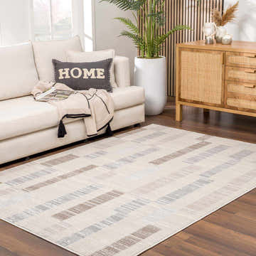 Living room scene with a Chouko Broken-Striped Area Rug in beige, brown, and silver tones under a white sofa. Roomscene-Rectangle