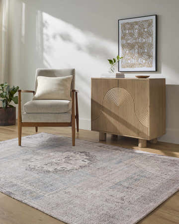 Living room scene with a Cassia Area Rug, gray chair, and light wood cabinet. Roomscene-Rectangle