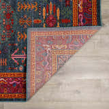 Close-up of the teal, aqua, and navy Cleveland Colorful Traditional Area Rug showing its bohemian pattern and texture. Fold