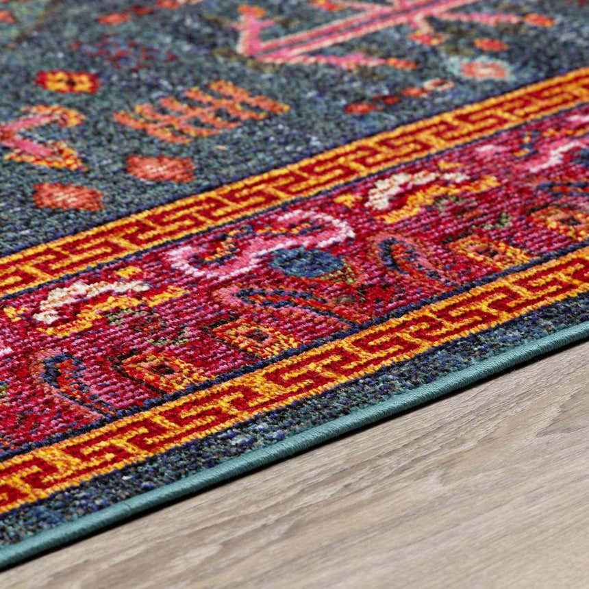 Close up of the Cleveland Colorful Traditional Area Rug showing teal, red, and yellow geometric patterns. Corner