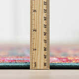 Close-up of the Cleveland Colorful Traditional Area Rug showing the rug's thickness with a ruler. Teal, red, and pink colors. Pile
