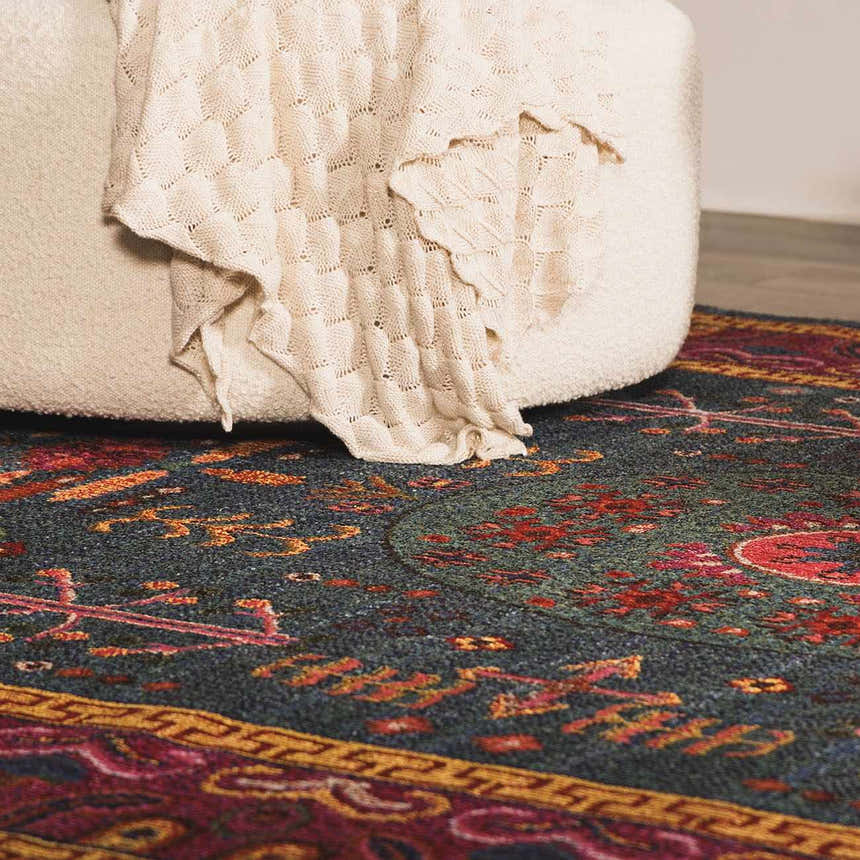 Close up of the teal Cleveland Colorful Traditional Area Rug with a cream ottoman and throw blanket. Roomscene-Rectangle