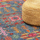 Close up of the teal Cleveland Colorful Traditional Area Rug with a jute pouf. Styleshot