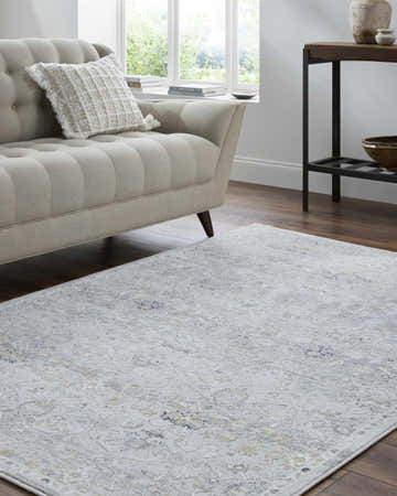 Living room scene with a light silver Cheree Area Rug, beige sofa, and dark wood floors. Roomscene-Rectangle